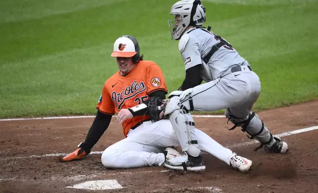 Detroit Tigers catcher Dillon Dingler, right, tags out Baltimore Orioles' Adley Rutschman, at home on a single by Heston Kjerstad during the fourth inning of a baseball game, Saturday, Sept. 21, 2024, in Baltimore. (AP Photo/Nick Wass)