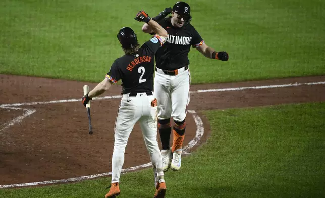 Baltimore Orioles' James McCann, right, celebrates his home run with Gunnar Henderson (2) during the sixth inning of a baseball game against the Detroit Tigers, Friday, Sept. 20, 2024, in Baltimore. (AP Photo/Nick Wass)