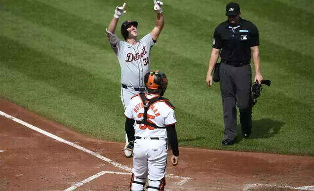 Detroit Tigers' Kerry Carpenter, top left, celebrates after his home run in front of Baltimore Orioles catcher Adley Rutschman (35) during the third inning of a baseball game Sunday, Sept. 22, 2024, in Baltimore. (AP Photo/Nick Wass)