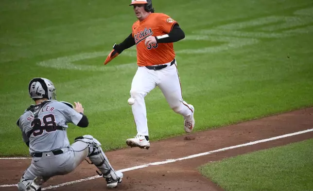 Baltimore Orioles' Adley Rutschman, right, runs towards home on a single by Heston Kjerstad as Detroit Tigers catcher Dillon Dingler, waits for the ball during the fourth inning of a baseball game, Saturday, Sept. 21, 2024, in Baltimore. Rutschman was tagged out at the plate. (AP Photo/Nick Wass)