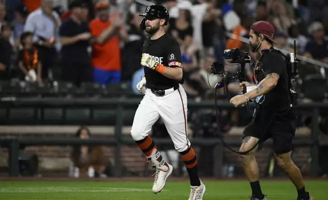 Baltimore Orioles' Colton Cowser, left, rounds the bases on his home run during the second inning of a baseball game against the Detroit Tigers, Friday, Sept. 20, 2024, in Baltimore. (AP Photo/Nick Wass)