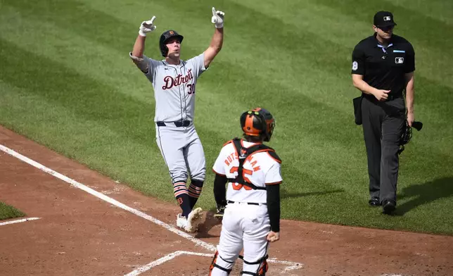 Detroit Tigers' Kerry Carpenter, left, celebrates after his home run in front of Baltimore Orioles catcher Adley Rutschman (35) during the sixth inning of a baseball game, Sunday, Sept. 22, 2024, in Baltimore. (AP Photo/Nick Wass)