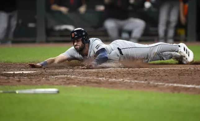 Detroit Tigers' Matt Vierling slides home to score on a single by Riley Greene during the tenth inning of a baseball game against the Baltimore Orioles, Saturday, Sept. 21, 2024, in Baltimore. (AP Photo/Nick Wass)