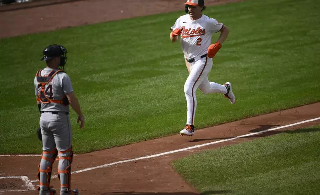 Baltimore Orioles' Gunnar Henderson (2) runs toward home to score on a double by Orioles' Jordan Westburg during the fifth inning of a baseball game as Detroit Tigers catcher Jake Rogers, left, looks on Sunday, Sept. 22, 2024, in Baltimore. (AP Photo/Nick Wass)