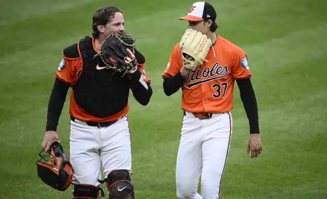 Baltimore Orioles catcher Adley Rutschman, left, and starting pitcher Cade Povich, talk as they walk back to the dugout after the top of the fifth inning of a baseball game against the Detroit Tigers, Saturday, Sept. 21, 2024, in Baltimore. (AP Photo/Nick Wass)