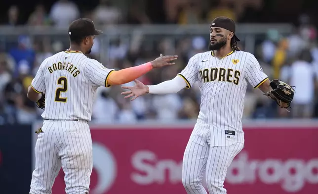 San Diego Padres right fielder Fernando Tatis Jr., right, celebrates with teammate second baseman Xander Bogaerts after the Padres defeated the Detroit Tigers 3-0 in a baseball game Monday, Sept. 2, 2024, in San Diego. (AP Photo/Gregory Bull)