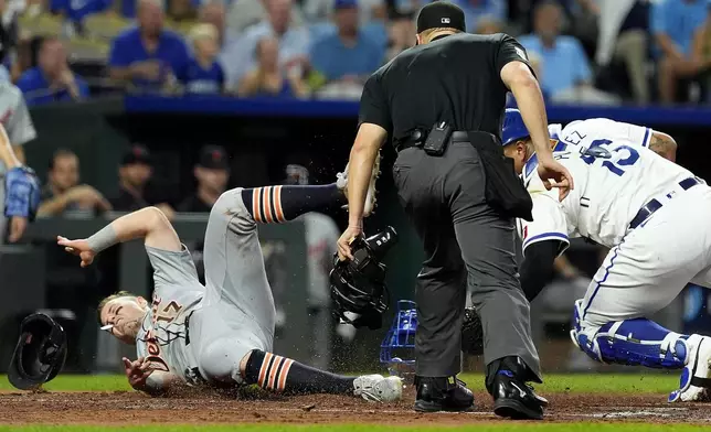 Detroit Tigers' Jace Jung (17) beats the tag by Kansas City Royals catcher Salvador Perez to score on a double by Trey Sweeney during the third inning of a baseball game Wednesday, Sept. 18, 2024, in Kansas City, Mo. (AP Photo/Charlie Riedel)