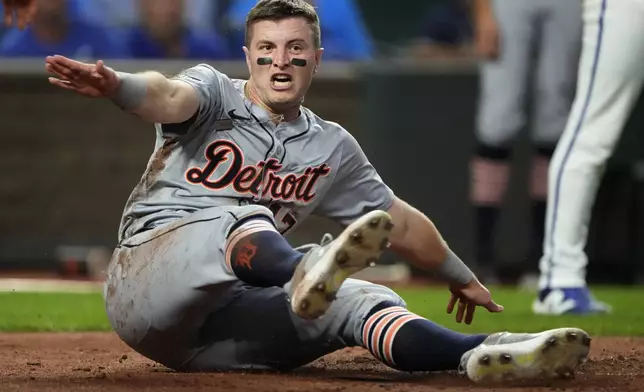 Detroit Tigers' Jace Jung slides home to score on a double by Trey Sweeney during the third inning of a baseball game against the Kansas City Royals Wednesday, Sept. 18, 2024, in Kansas City, Mo. (AP Photo/Charlie Riedel)