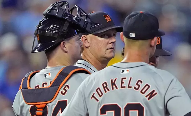 Detroit Tigers manager A.J. Hinch talks to his players on the mound as he makes a pitching change during the third inning of a baseball game against the Kansas City Royals Monday, Sept. 16, 2024, in Kansas City, Mo. (AP Photo/Charlie Riedel)