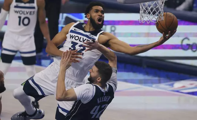 FILE - Minnesota Timberwolves center Karl-Anthony Towns (32) drives to the basket over Dallas Mavericks forward Maxi Kleber (42) during the second half in Game 4 of the NBA basketball Western Conference finals, Tuesday, May 28, 2024, in Dallas. (AP Photo/Gareth Patterson, File)