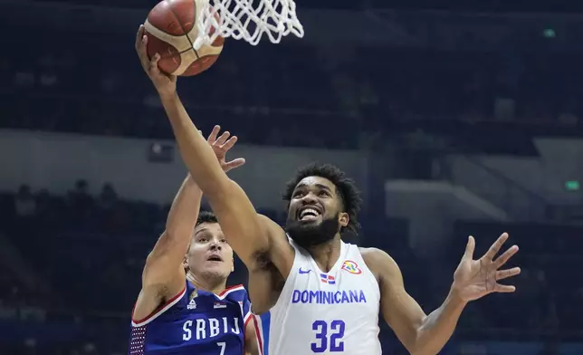 FILE - Dominican Republic forward Karl-Anthony Towns (32) against Serbia guard Bogdan Bogdanovic (7) during their Basketball World Cup second round match at the Araneta Coliseum, Manila, Philippines on Sunday Sept. 3, 2023. (AP Photo/Aaron Favila, File)