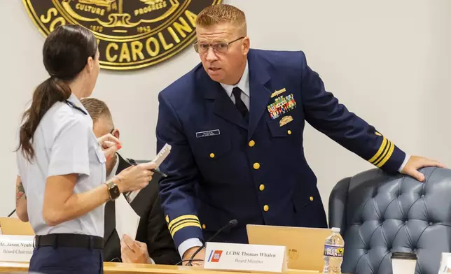 Coast Guard's Thomas Whalen speaks with another Coast Guard member during a break for the Titan marine board formal hearing inside the Charleston County Council Chambers, Monday, Sept. 16, 2024, in North Charleston, S.C. (AP Photo/Mic Smith)