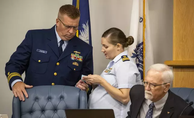 Guard investigative board member Thomas Whalen, Coast, left, and Katie Williams, of the Coast Guard, right, huddle Tuesday, Sept. 17, 2024, during a recess for the Titan marine board formal hearing, in North Charleston, S.C. (Andrew J. Whitaker/The Post And Courier via AP, Pool)