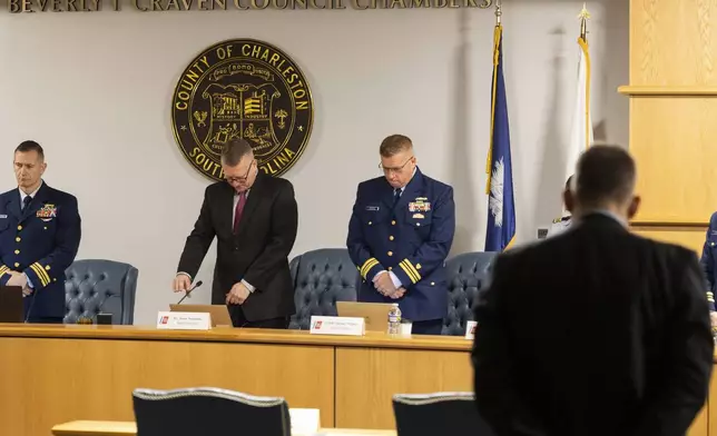 Coast Guard members of the investigative board for the Titan marine board formal hearing pause for a moment of silence inside the Charleston County Council Chambers Monday, Sept. 16, 2024, in North Charleston, S.C. (AP Photo/Mic Smith)