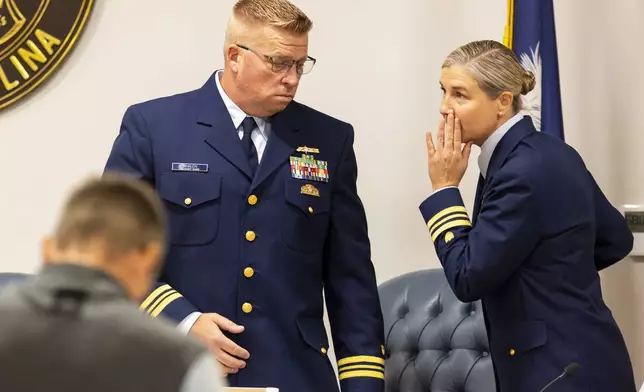 Coast Guard's Thomas Whalen, left, speaks with Nicole Emmons, right, during a break for the Titan marine board formal hearing inside the Charleston County Council Chambers, Monday, Sept. 16, 2024, in North Charleston, S.C. (AP Photo/Mic Smith)