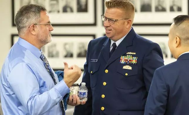 Matthew McCoy, at left, a former OceanGate employee, talks with the Coast Guard's Thomas Whalen after testimony ended during the final day of the Coast Guard investigatory hearing on the causes of the implosion of an experimental submersible headed for the wreck of the Titanic, Friday, Sept. 27, 2024, in North Charleston, S.C. (AP Photo/Mic Smith)