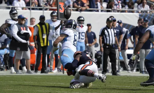 Tennessee Titans quarterback Will Levis throws an interception for a Bears' touchdown off pressure from defensive end DeMarcus Walker during the second half of an NFL football game Sunday, Sept. 8, 2024, in Chicago. (AP Photo/Nam Y. Huh)