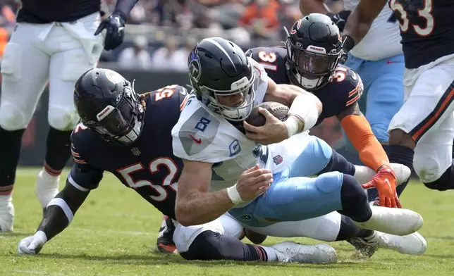 Tennessee Titans quarterback Will Levis carries the ball and is tackled by Chicago Bears linebacker T.J. Edwards (53) and safety Kevin Byard III (31) during the first half of an NFL football game Sunday, Sept. 8, 2024, in Chicago. (AP Photo/Nam Y. Huh)