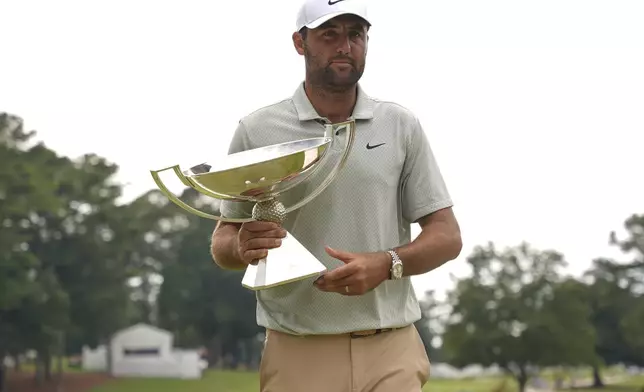 Scottie Scheffler poses with the FedExCup Trophy after the final round of the Tour Championship golf tournament, Sunday, Sept. 1, 2024, in Atlanta. (AP Photo/Jason Allen)