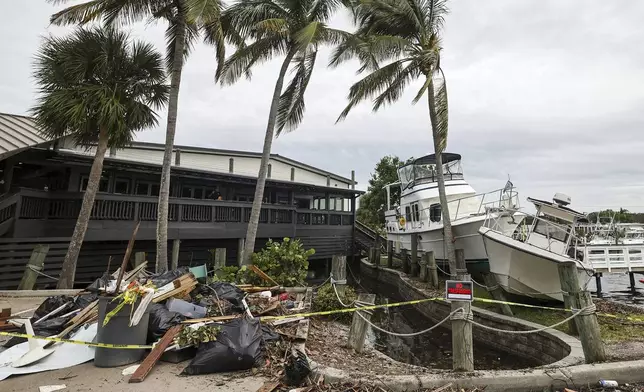 Boats rest beside a restaurant after being pushed up by floodwaters from Hurricane Helene on Saturday, Sept. 28, 2024, in St. Petersburg, Fla. (AP Photo/Mike Carlson)