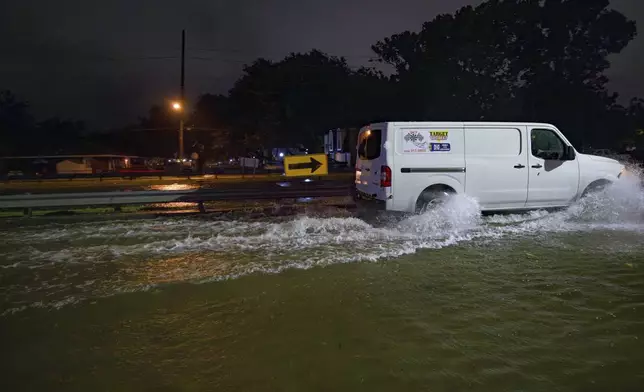 The W. Napoleon Ave drainage canal, behind guard rail, is about even with the road which is submerged with floodwaters. The W. Napoleon drainage canal overtopped after a deluge of rain from Hurricane Francine in Metairie, La., in Jefferson Parish, Wednesday, Sept. 11, 2024. (AP Photo/Matthew Hinton)