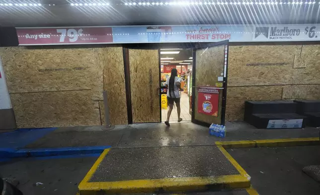 A customer enters a gas station that is boarded up in anticipation of Hurricane Francine, in Morgan City, La., Wednesday, Sept. 11, 2024. (AP Photo/Gerald Herbert)