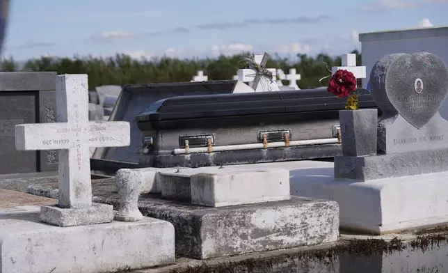 A casket sits on tombs after being disturbed by flooding, in the aftermath of Hurricane Francine, in Dulac, La., Thursday, Sept. 12, 2024. (AP Photo/Gerald Herbert)