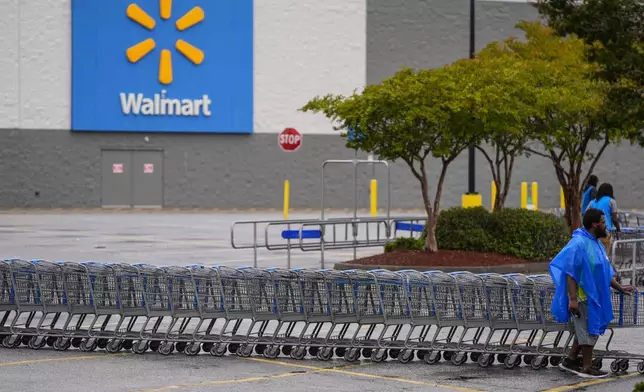 Workers clear shopping carts from the parking lot at a Walmart that just closed ahead of Hurricane Helene, expected to make landfall Thursday evening, Thursday, Sept. 26, 2024, in Valdosta, Ga. (AP Photo/Mike Stewart)