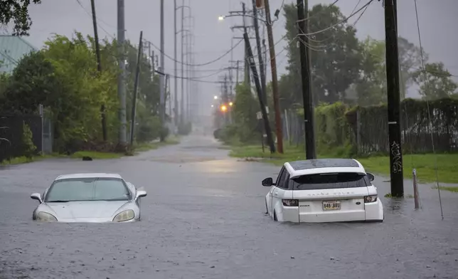 Two vehicle on Olive street are flooded during Hurricane Francine in New Orleans, Wednesday, Sept. 11, 2024. (David Grunfeld/The Times-Picayune via AP)