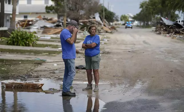 Leslie Sturmer, a University of Florida employee, and John Rittenhouse, general manager of the Cedar Key Water and Sewer District, both residents, talk in the aftermath of Hurricane Helene, in Cedar Key, Fla., Friday, Sept. 27, 2024. (AP Photo/Gerald Herbert)