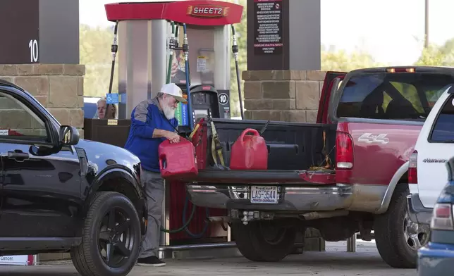 After waiting on long lines to fill up their gas tanks at the Sheetz station, people were also filling up containers of gas for their generators after Hurricane Helene caused power outages, Saturday, Sept. 28, 2024, in Morganton, N.C. (AP Photo/Kathy Kmonicek)