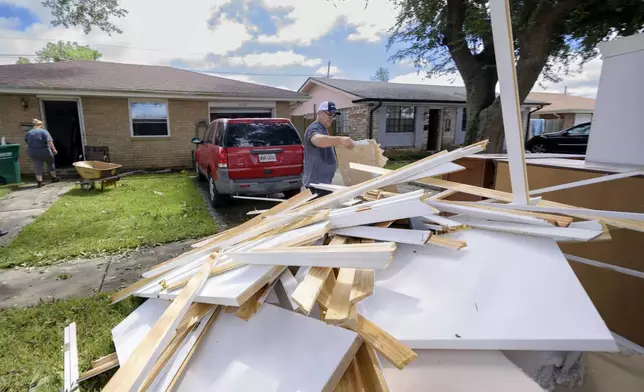 Shawn Murphy removes drywall at a friend's house after floodwater came up a few inches in the house making most of the walls, floors, and doors wet after Hurricane Francine in Kenner, La., in Jefferson Parish, Thursday, Sept. 12, 2024. (AP Photo/Matthew Hinton)