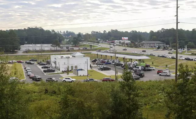 Residents wait in long lines for gas at Parker's Kitchen in the aftermath of Hurricane Helene Sunday, Sept. 29, 2024, in Aiken, S.C. (AP Photo/Artie Walker Jr.)