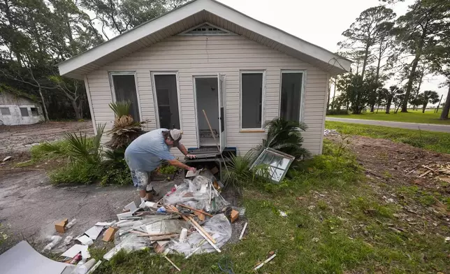 Will Marx cleans up remodeling debris in advance of Tropical Storm Helene, expected to become a hurricane before landfall, in Panacea, Fla., Wednesday, Sept. 25, 2024. (AP Photo/Gerald Herbert)