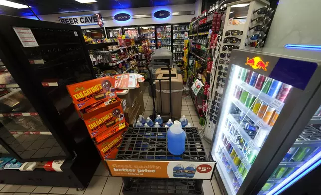 Outside trash cans and product displays are moved inside a boarded up gas station in anticipation of Hurricane Francine, in Morgan City, La., Wednesday, Sept. 11, 2024. (AP Photo/Gerald Herbert)