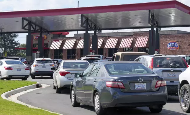 Long lines for gasoline are seen at a station Saturday, Sept. 28, 2024 in Morganton, N.C. The remnants of Hurricane Helene left area residents with no power, downed trees and lack of everyday necessities. (AP Photo/Kathy Kmonicek)