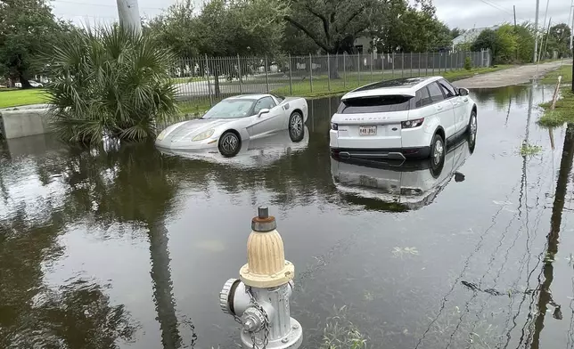 Stalled cars sit at a flooded intersection in New Orleans on Thursday, Sept. 12,, 2024, the morning after Hurricane Francine hit the city. (AP Photo/Kevin McGill)