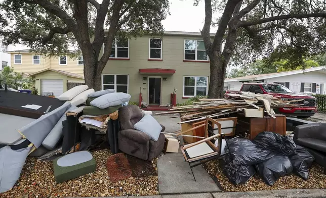 Contents of homes are piled on the side of the road after flooding from Hurricane Helene on Davis Island Saturday, Sept. 28, 2024, in Tampa, Fla. (AP Photo/Mike Carlson)