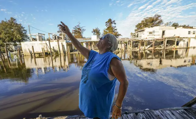 Debra Matherne describes her experience as she rode out Hurricane Francine the previous night, along Bayou Pointe-au-Chien, La., Thursday, Sept. 12, 2024. (AP Photo/Gerald Herbert)