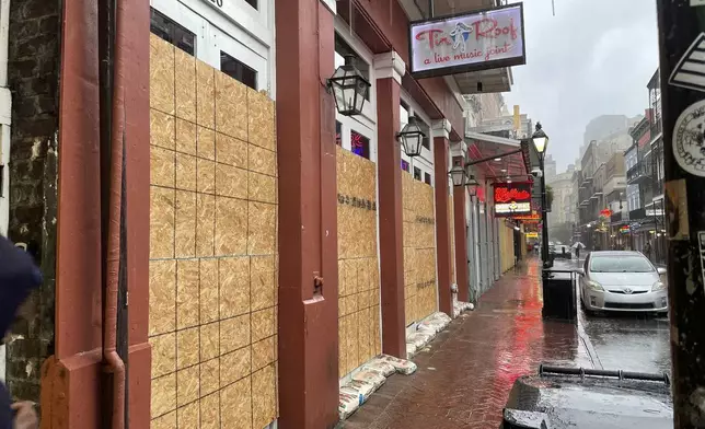 Boarded windows and sandbags cover the windows of a Bourbon Street bar in New Orleans' French Quarter, Wednesday, Sept. 11, 2024, as the city was bracing for high winds and possible flooding as Hurricane Francine approached Louisiana's coast. (AP Photo/Kevin McGill)