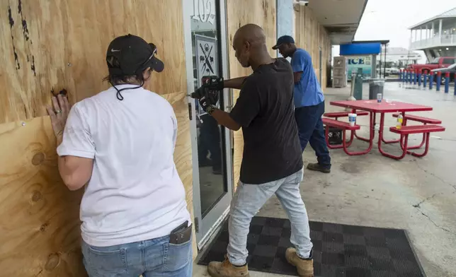 Maintenance workers for Keith's Superstores put up plywood on the Pass Christian, Miss. location in preparation for Hurricane Francine on Tuesday, Sept. 10, 2024. (Hannah Ruhoff/The Sun Herald via AP)