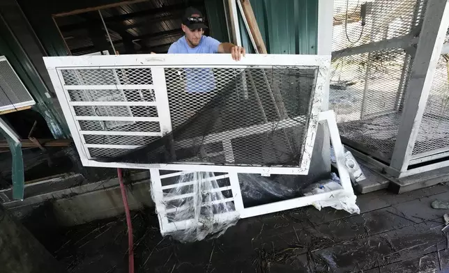 Jansen Pellegrin puts out damaged doors as he helps clean out his family's camp, that took on a storm surge, in the aftermath of Hurricane Francine, in Cocodrie, La., Thursday, Sept. 12, 2024. (AP Photo/Gerald Herbert)