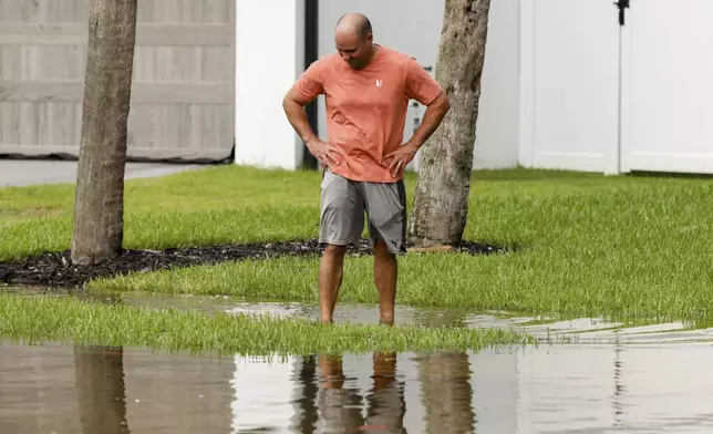 Eric Midili, 45, examines and walks around a flooded street around the Sunset Park neighborhood as Hurricane Helene makes its way toward the Florida panhandle on Thursday, Sept. 26, 2024, in Tampa, Fla. (Jefferee Woo/Tampa Bay Times via AP)