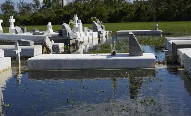 Tombs are seen after being disturbed by flooding, in the aftermath of Hurricane Francine, in Dulac, La., Thursday, Sept. 12, 2024. (AP Photo/Gerald Herbert)