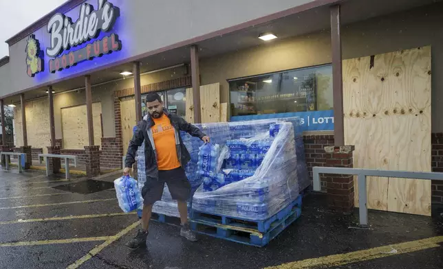 A customer buys water at a mostly boarded up Birdies Food and Fuel, Wednesday, Sept. 11, 2024, in Luling, La., ahead of Hurricane Francine. (David Grunfeld/The Times-Picayune/The New Orleans Advocate via AP)