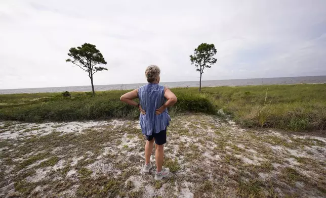 Paulette McLin takes in the scene outside their summer home ahead of Hurricane Helene, expected to make landfall Thursday evening, in Alligator Point, Fla., Wednesday, Sept. 25, 2024. (AP Photo/Gerald Herbert)