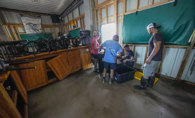 The Pellegrin family cleans up the damage from a storm surge in their family's camp in the aftermath of Hurricane Francine in Cocodrie, La., Thursday, Sept. 12, 2024. (AP Photo/Gerald Herbert)