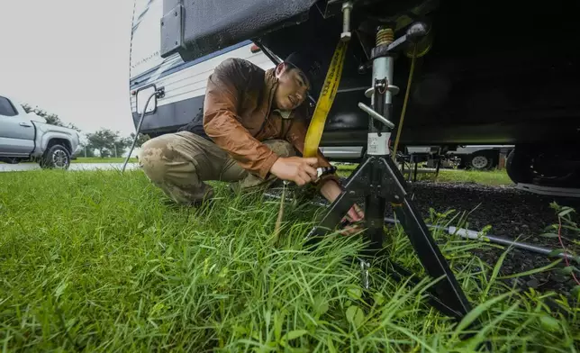 Luis Morfin ratchets his trailer to jack supports as he prepares for Hurricane Francine at a trailer park in Morgan City, La., Wednesday, Sept. 11, 2024. (AP Photo/Gerald Herbert)