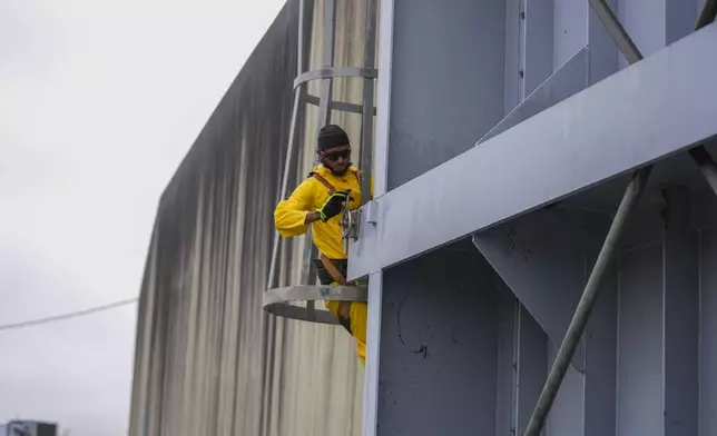 A worker from the Southeast Louisiana Flood Protection Authority-West tightens turnbuckles as they close floodgates along the Harvey Canal, just outside the New Orleans city limits, in anticipation of Tropical Storm Francine, in Harvey, La., Tuesday, Sept. 10, 2024. (AP Photo/Gerald Herbert)