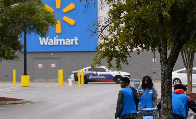 Workers clear shopping carts from the parking lot at a Walmart that just closed ahead of Hurricane Helene, expected to make landfall Thursday evening, Thursday, Sept. 26, 2024, in Valdosta, Ga. (AP Photo/Mike Stewart)